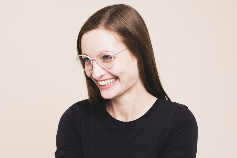 Fröhliche junge Frau trägt eine zarte helle aktuelle Brille aus dem hause Annu