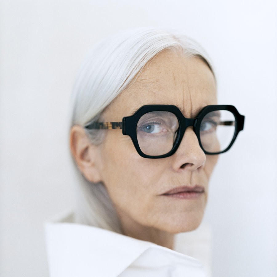 Ausdrucksvolle dunkle Brille wird von älterem Model getragen vor hellem Hintergrund